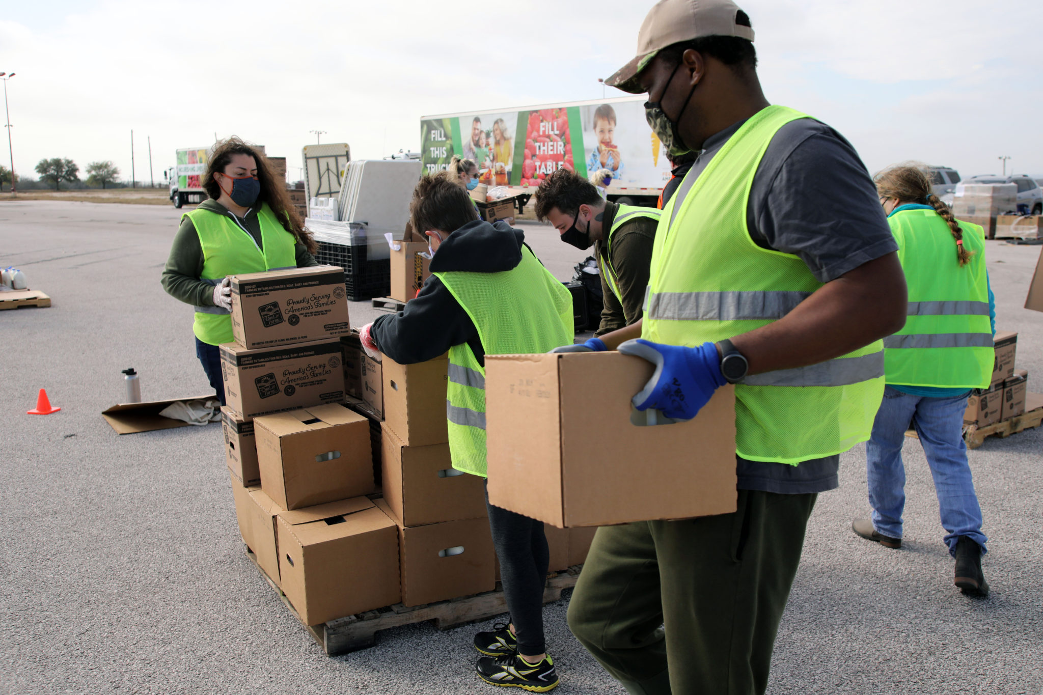 Austin, TX - Volunteers organize emergency food aid being distributed by the Central Texas Food Bank to people in need at a drive through event at the Exposition Center.